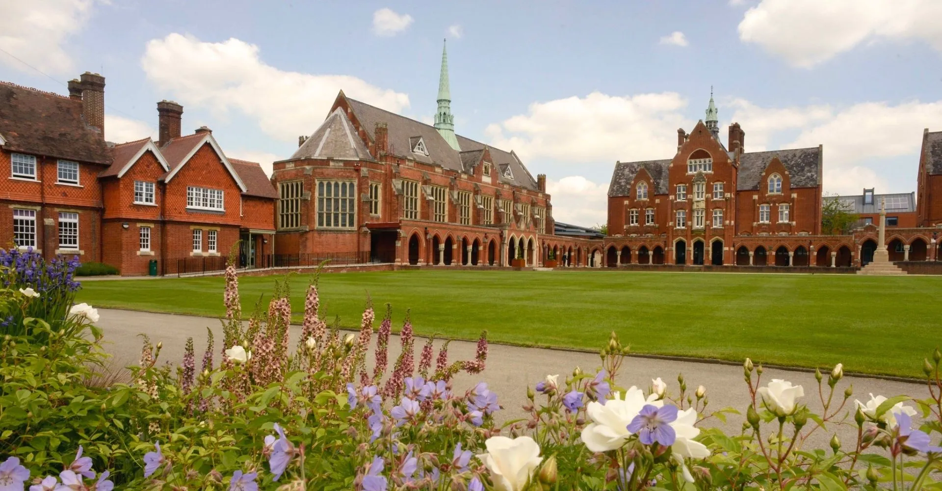 L'edificio storico in mattoni con un'alta torre nel verde campus della St. John’s School a Leatherhead.