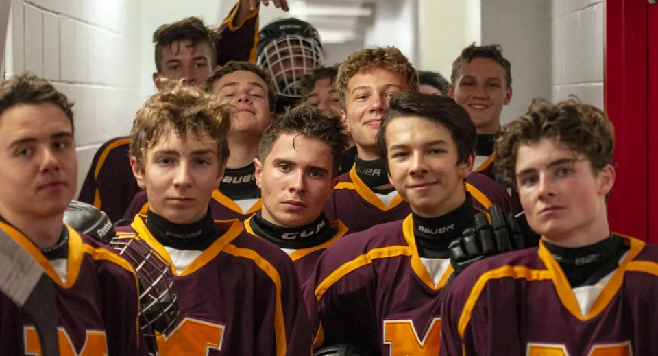 Un gruppo di studenti della Merivale High School posa con le maglie sportive in uno spogliatoio.