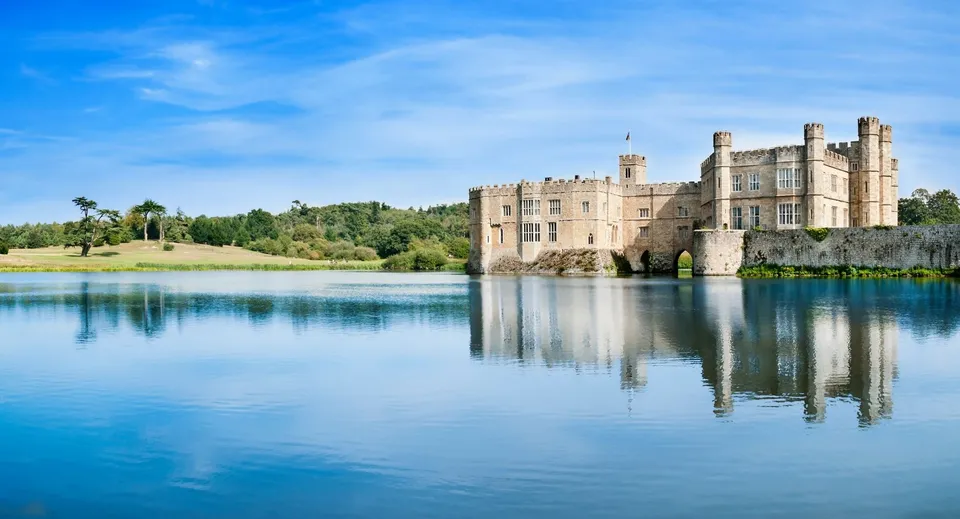 L'edificio storico della Ackworth School situato accanto a un lago che riflette la sua struttura.
