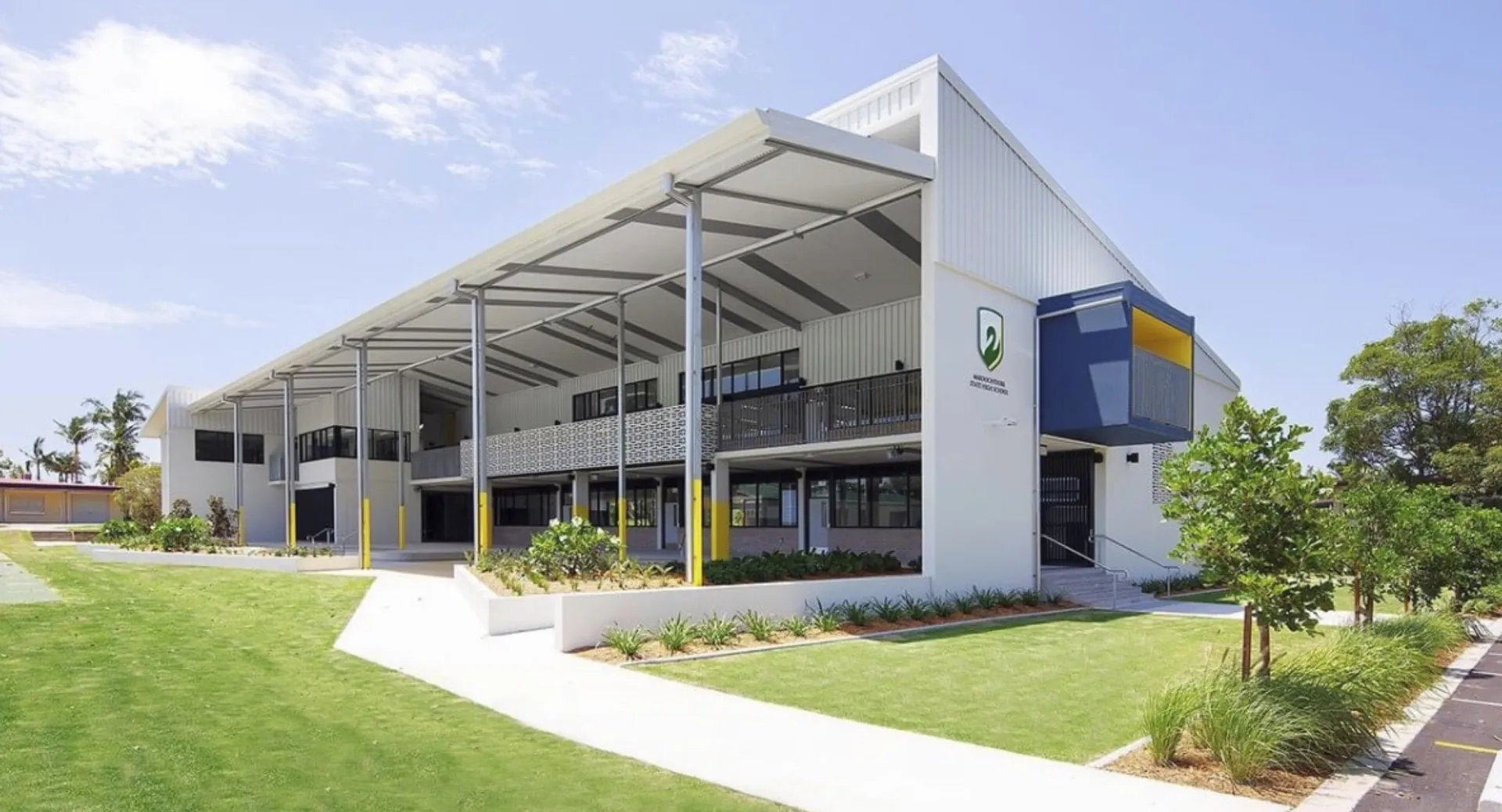 L'edificio principale moderno della Maroochydore State High School con un prato curato e dintorni verdi.