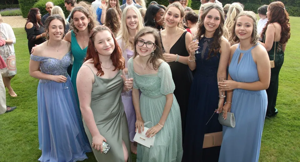 Un gruppo di giovani donne posa sorridente in abiti formali nell'area esterna del Mullingar Community College.