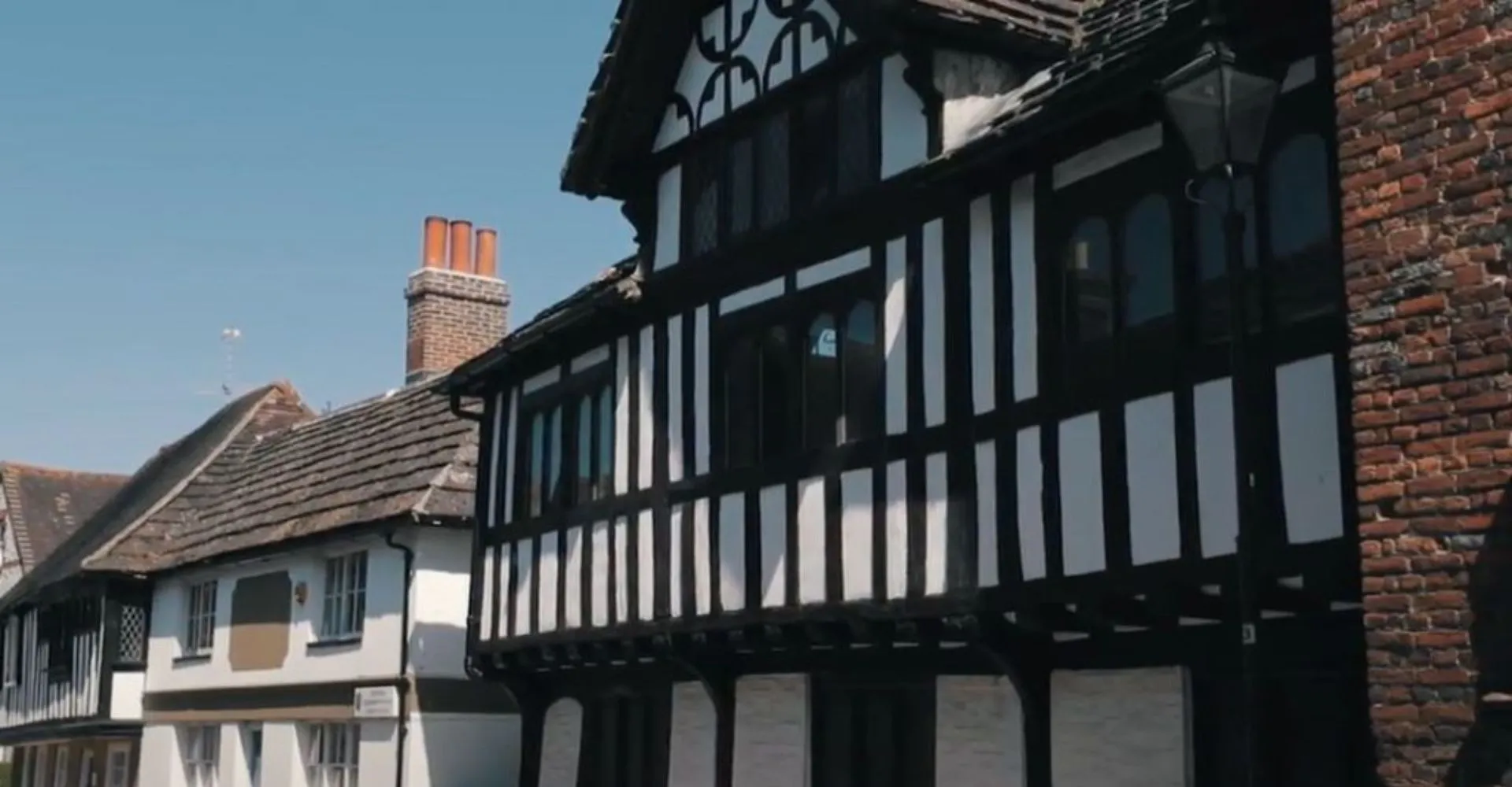 L'edificio storico a graticcio sul campus della Steyning Grammar School and Sixth Form si staglia contro un cielo blu limpido.