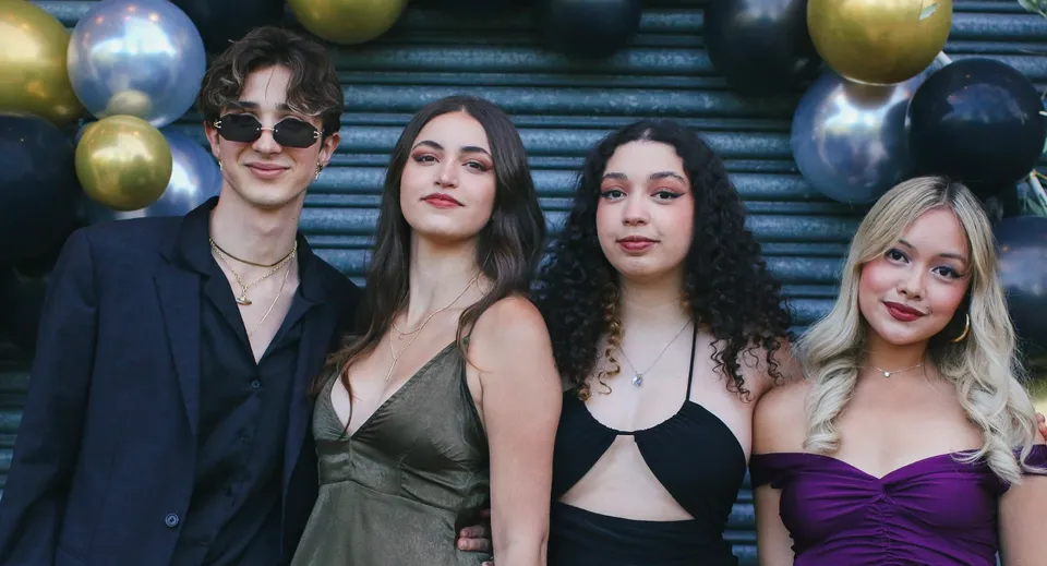 Quattro persone, due donne e due uomini, posano davanti a palloncini colorati all'Oxford Sixth Form College.