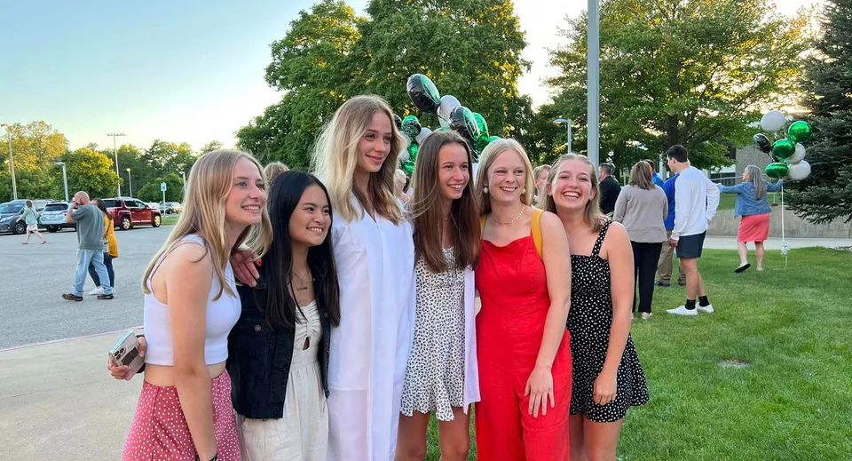 Un gruppo di studentesse nell'area esterna della Western Michigan Christian School davanti ad alberi e a un prato.