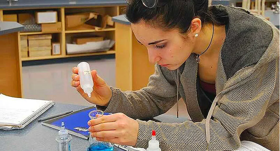 Un alunno della Byrne Creek School si concentra su un piccolo oggetto nelle sue mani in classe.