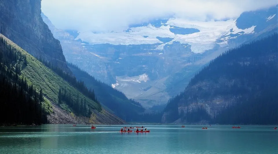 Un tranquillo lago alpino con barche rosse e montagne innevate sullo sfondo vicino alla Assumption College Catholic High School.