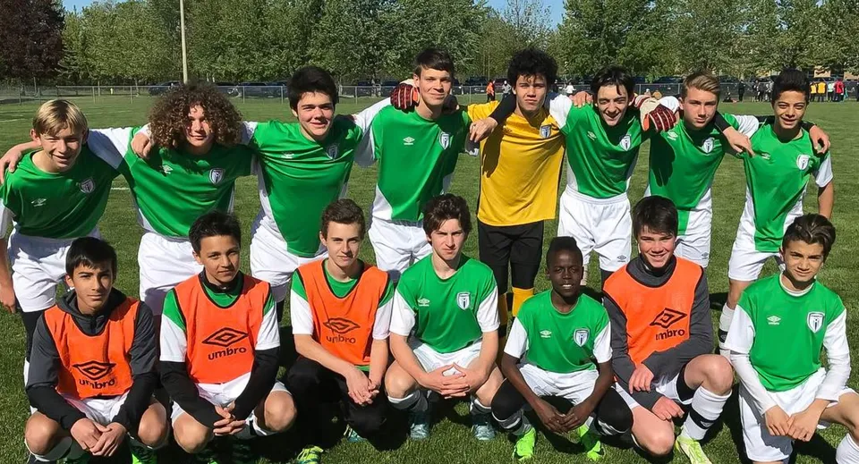 Un gruppo di studenti del Woodbridge College in maglia da calcio posa sul prato per una foto di squadra.