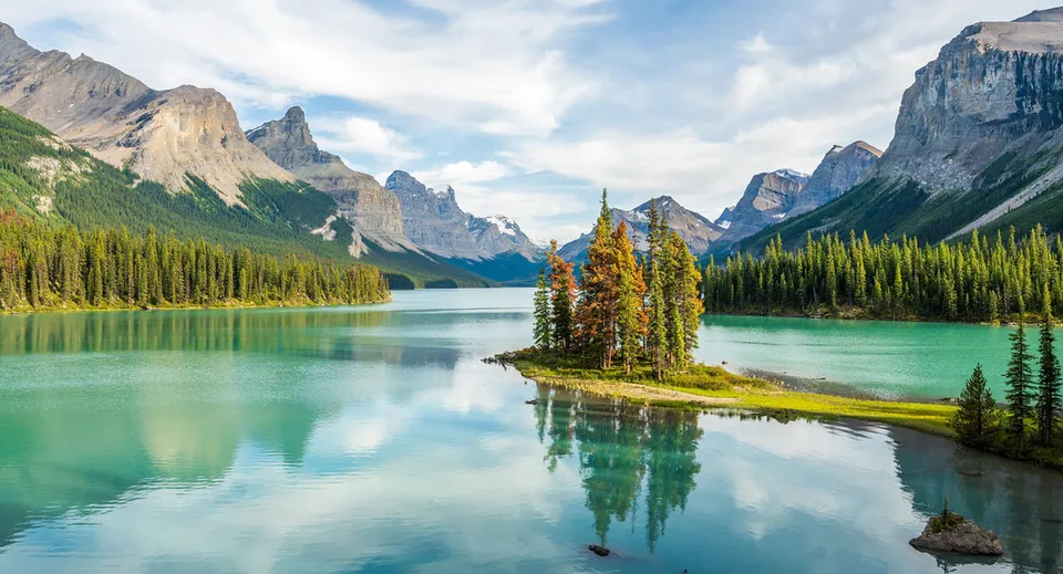 Un lago tranquillo con montagne innevate e boschi verdi sullo sfondo vicino alla Strathmore High School.