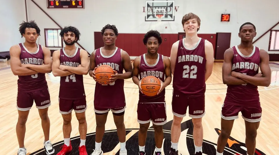 Un gruppo di giovani giocatori e giocatrici di basket della Darrow School sta insieme sul campo da basket.