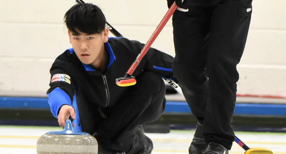 Una studentessa della Fulford Academy tiene una pietra da curling sulla pista da ghiaccio durante la lezione di educazione fisica.