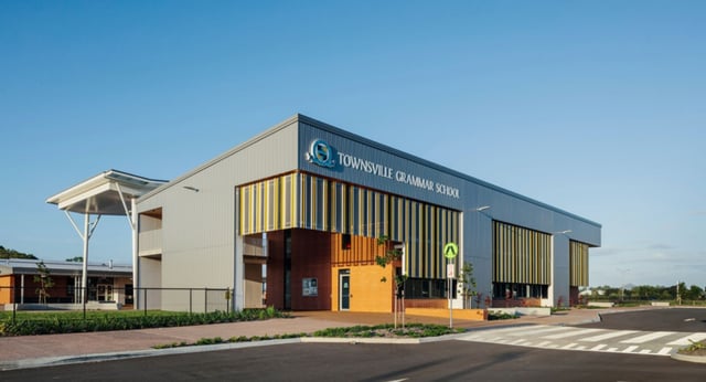 Das moderne mehrstöckige Gebäude der Townsville Grammar School mit Logo und Parkplatz im Vordergrund.