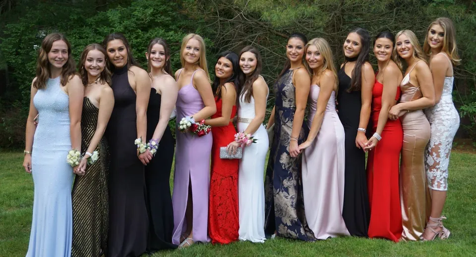 Un gruppo di giovani donne in abito formale insieme nell'area verde esterna della Scoil Mhuire Cork.