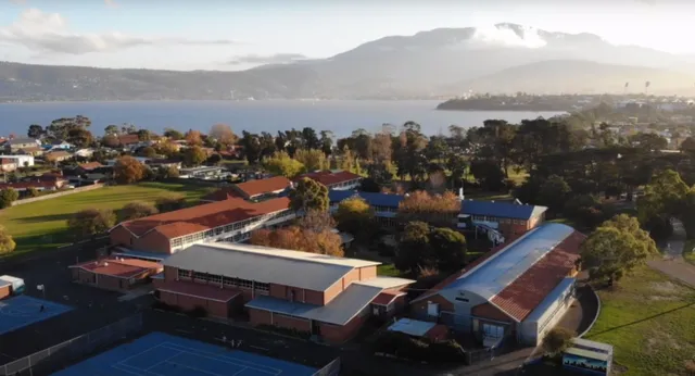 Eine malerische Seenlandschaft mit einer kleinen Stadt und Hügeln im Hintergrund, ohne direkten Bezug zur Clarence High School.