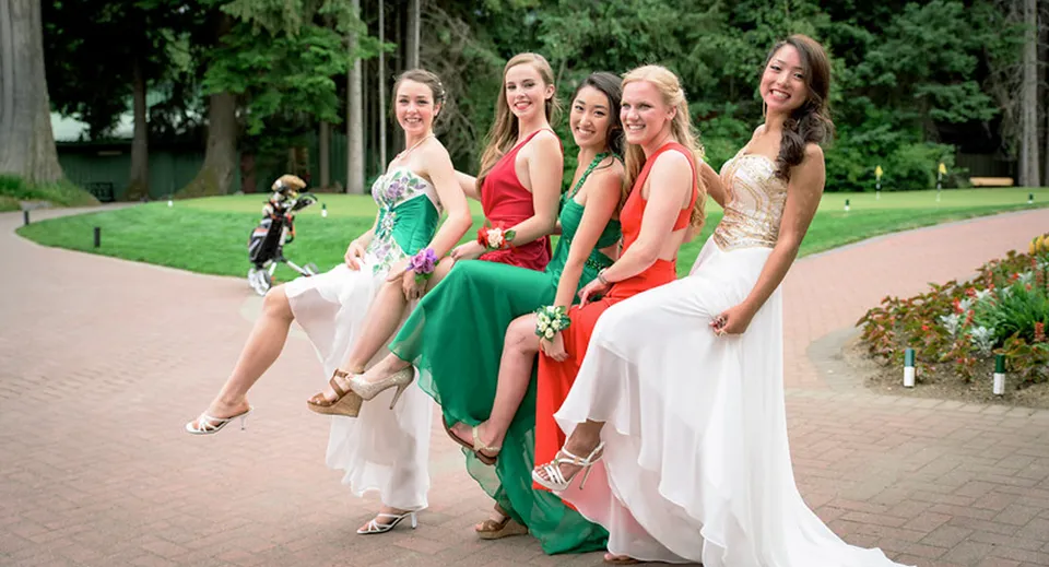 Un gruppo di giovani donne in abiti eleganti si trova nell'area esterna della Whistler Secondary School.