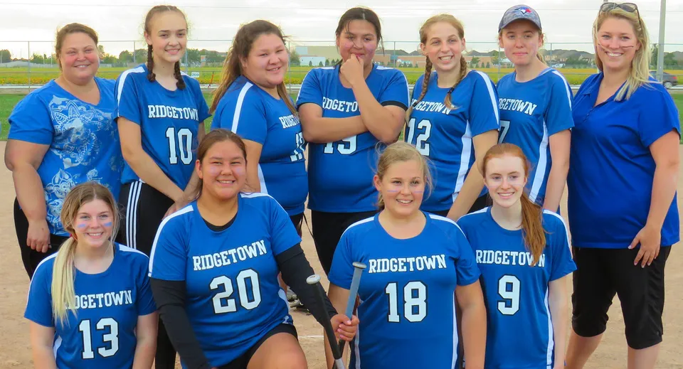 Un gruppo di giovani atlete è insieme sul campo sportivo della Ridgetown District High School.