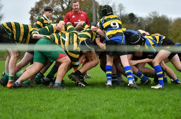 Melé de rugby entre dos equipos escolares en el campo
