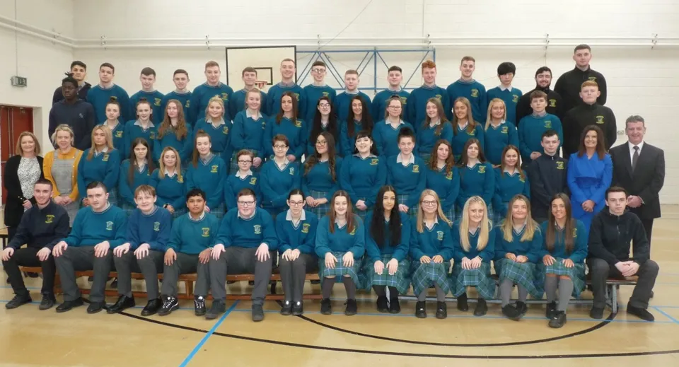 Un grande gruppo di studenti della Donahies Community School in uniforme scolastica blu e nera assiste a un'assemblea.