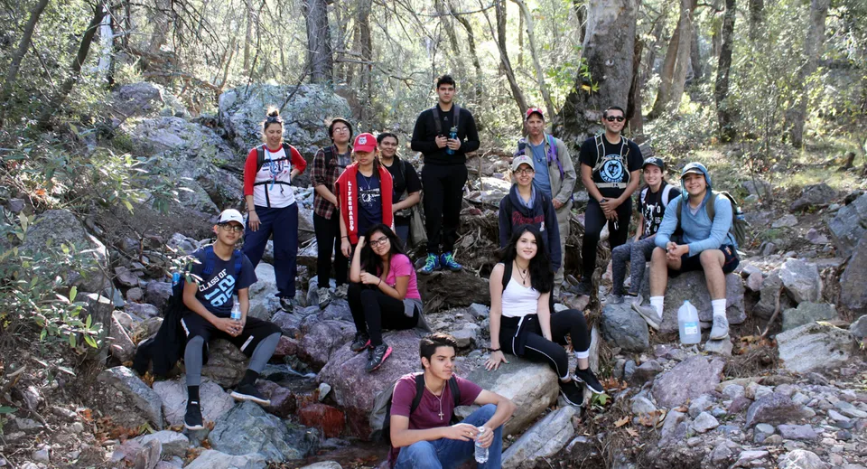 Un gruppo di giovani si trova su un sentiero roccioso nel bosco all'interno del terreno del Worksop College.