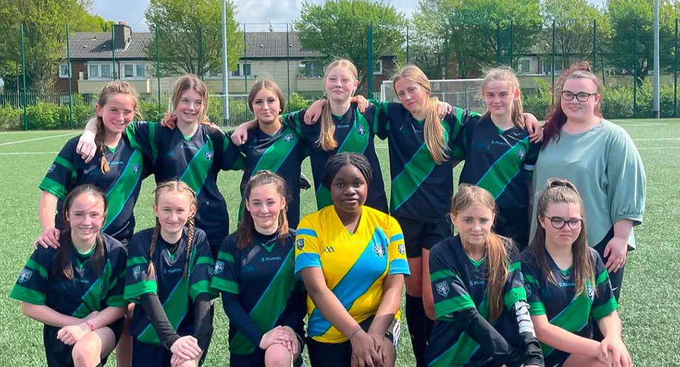 Un gruppo di calciatrici posa sul campo sportivo della Cabinteely Community School.
