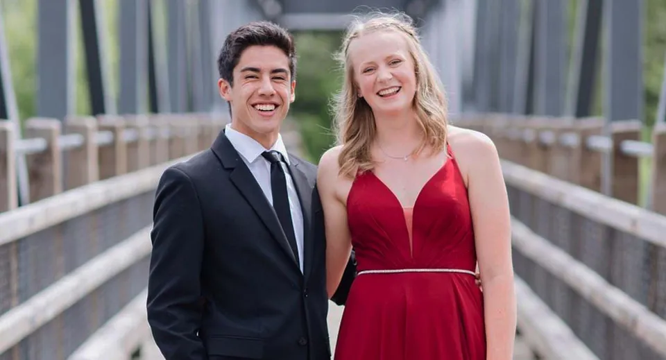 Una giovane coppia sorride su un ponte all'interno del campus della Revelstoke Secondary School.
