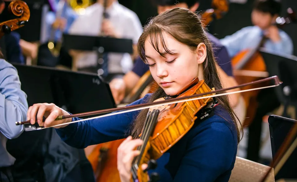 Un'alunna della Northern Academy suona concentrata il violino durante un'esibizione musicale.