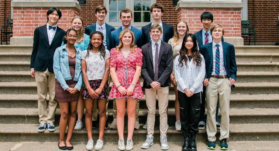 Studenti della Virginia Episcopal School sono sui gradini di un edificio in mattoni e posano per una foto di gruppo.