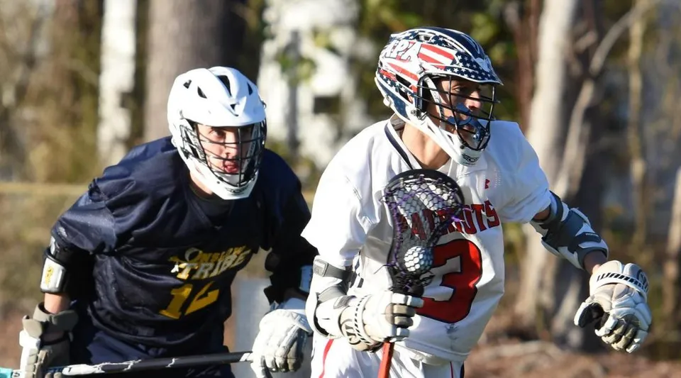 Due giocatori di lacrosse camminano insieme sul campo da gioco della Arendell Parrott Academy.