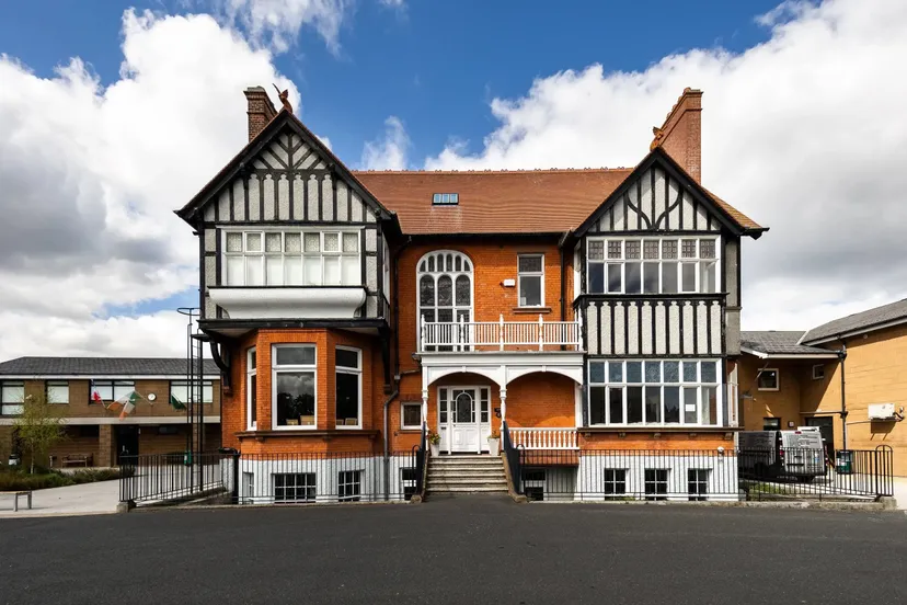 L'edificio storico della Sandford Park School a Dublino con facciata in mattoni rossi ed elementi in graticcio.