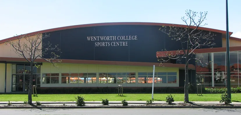 Il Wentworth College mostra il suo grande centro sportivo con tetto curvo e vegetazione circostante.