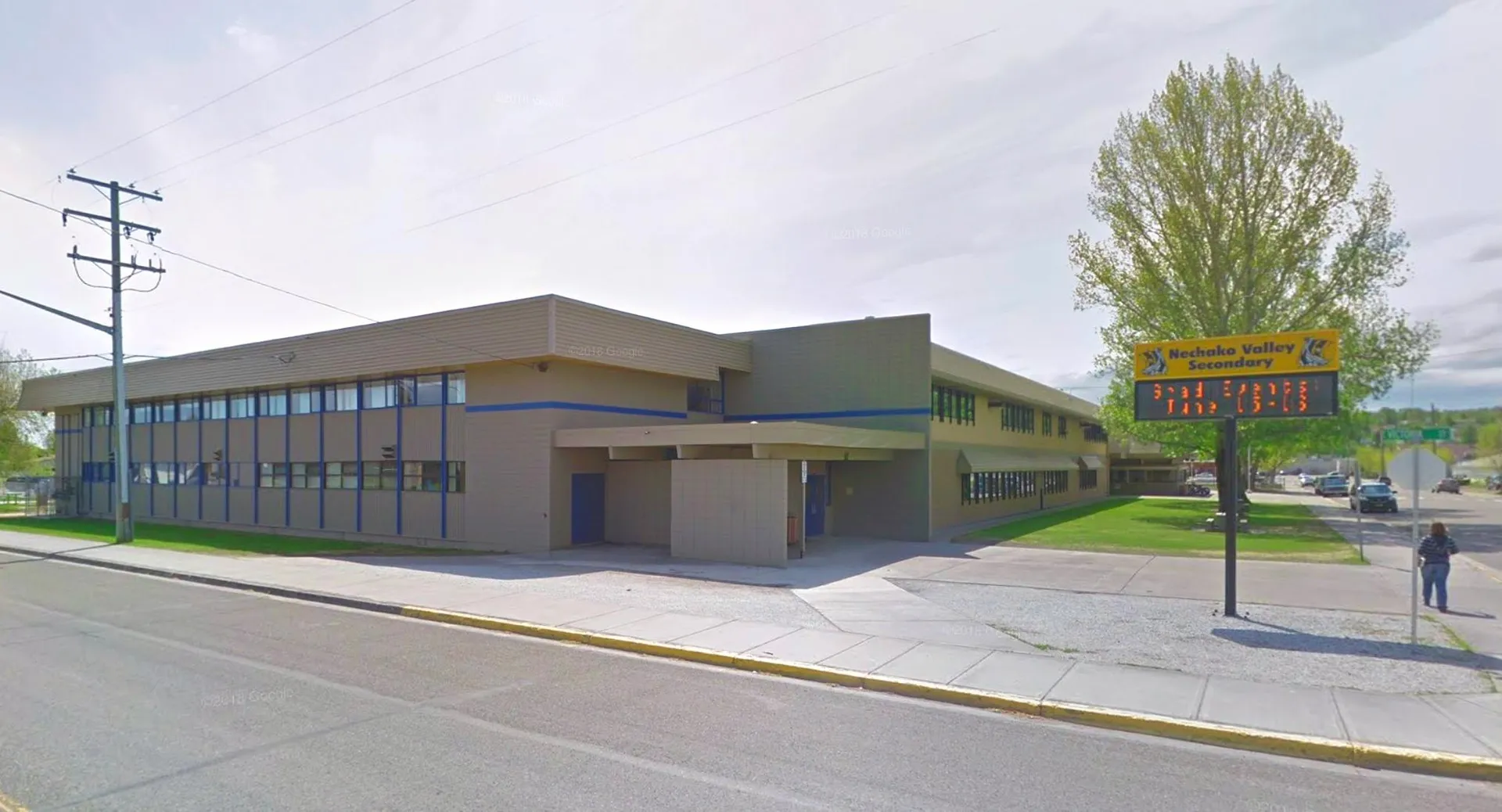 L'edificio moderno della Nechako Valley Secondary School si trova ad un angolo di strada con ampie finestre e un'insegna ben visibile.