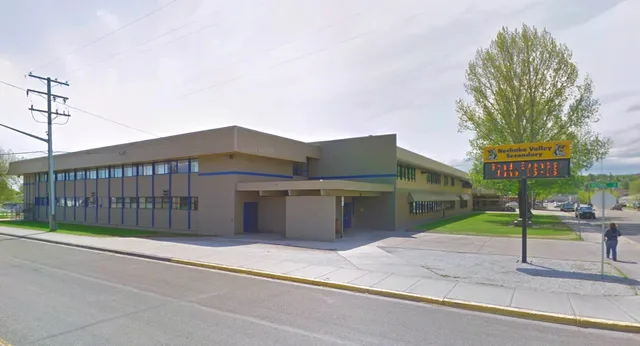 El moderno edificio de Nechako Valley Secondary School está en una esquina con grandes ventanas y un cartel bien visible.