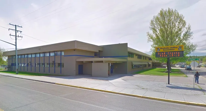 L'edificio moderno della Nechako Valley Secondary School si trova ad un angolo di strada con ampie finestre e un'insegna ben visibile.