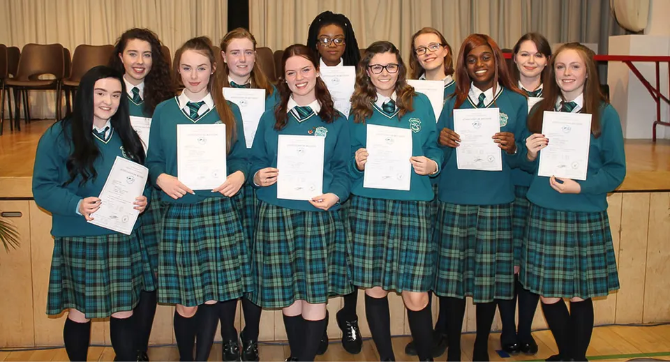 Un gruppo di studenti e studentesse della St. Paul’s Secondary a Galway mostra i propri premi in un'aula scolastica.