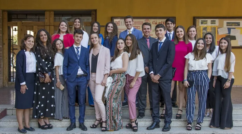 Un gruppo di studenti si trova in una stanza in legno con quadri incorniciati alla parete nel campus della scuola San Vicente de Paul.
