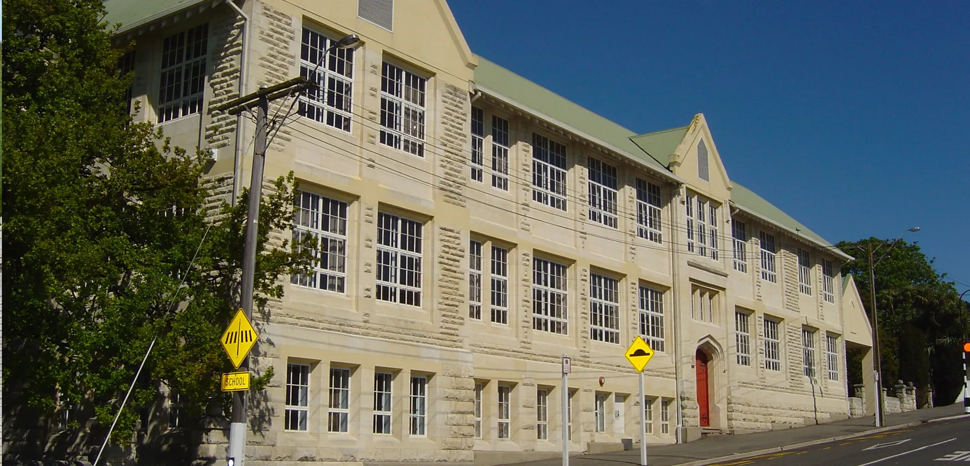 L'edificio in mattoni a più piani con grandi finestre e la porta rossa si trova nel campus della Waitaki Girls’ High School.
