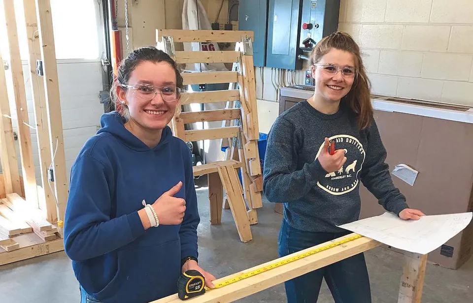 Due studentesse della Selkirk Secondary School lavorano insieme in un laboratorio a un progetto creativo.