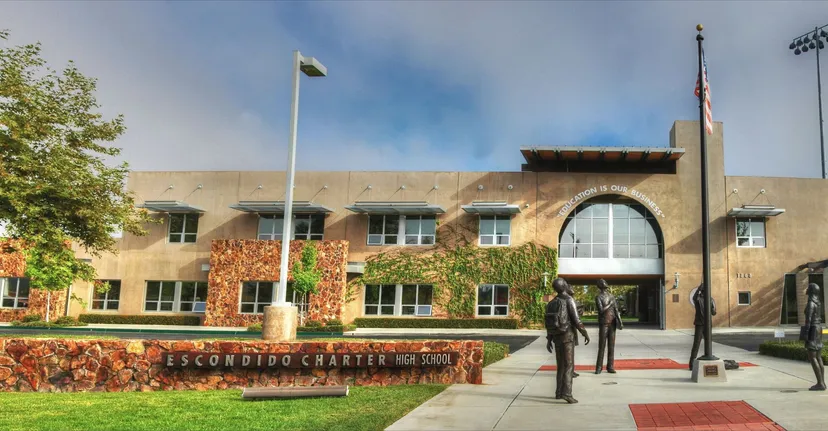 Si vede il moderno edificio a più piani della Escondido Charter High School con ingresso ad arco e area verde circostante.