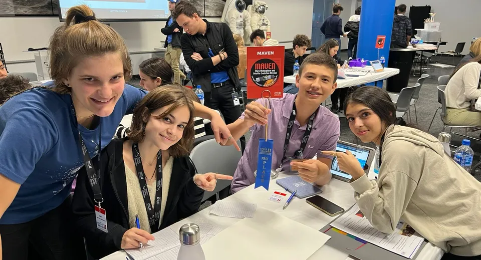 Un gruppo di studenti della SEK International School Catalunya è riunito attorno a un tavolo durante un evento.