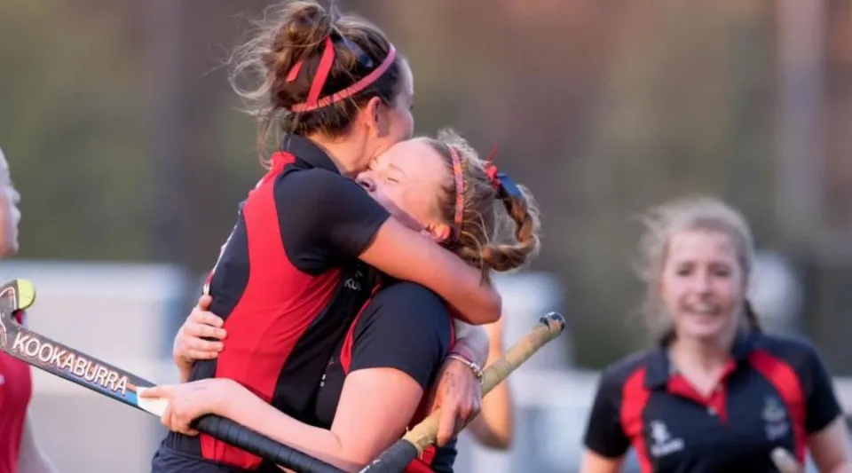 Due studentesse della Mary Erskine School in divisa sportiva si abbracciano sul campo da gioco.