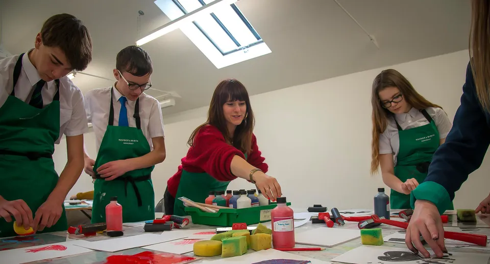 Un gruppo di studenti della Somerset Studio School lavora nell'aula d'arte con diversi materiali a un compito pratico.