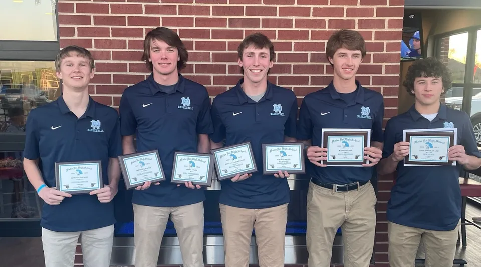 Cinque studenti della Mater Dei Catholic High School sono in piedi davanti a un muro di mattoni e tengono in mano premi e certificati.