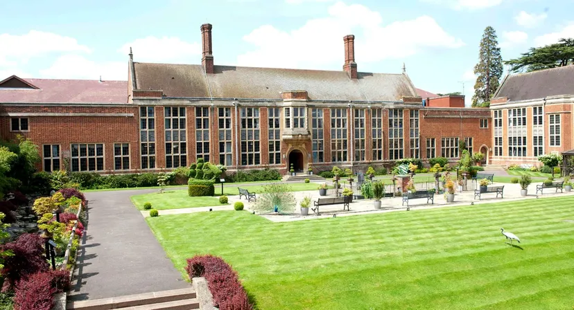 Il grande edificio in mattoni della Whitgift School è circondato da un prato curato con siepi e aiuole fiorite.