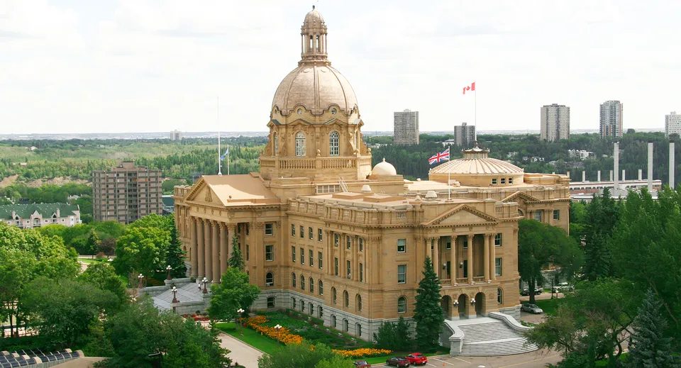 Un imponente edificio governativo con cupola e torre davanti a uno skyline moderno nel campus della McNally High School.