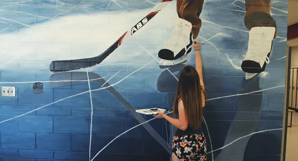 Il murale della NorKam Secondary School mostra un giocatore di hockey con stecca e disco su una pista da ghiaccio.