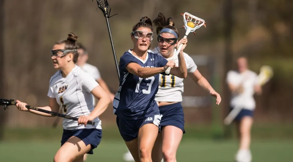 Studenti della St. Mark's School giocano a lacrosse su un campo sportivo con lo sfondo sfocato.