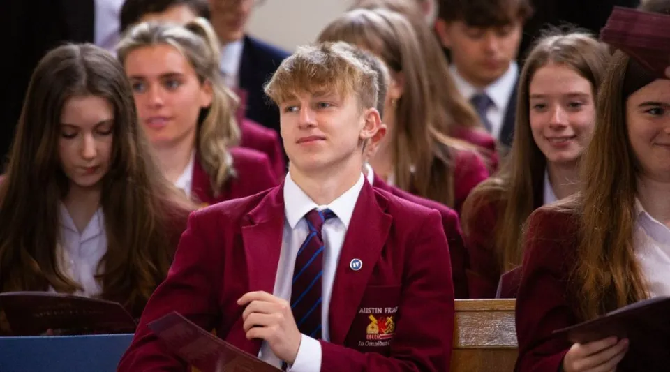 Un gruppo di studenti in divisa scolastica si trova sul campus della Austin Friars School.