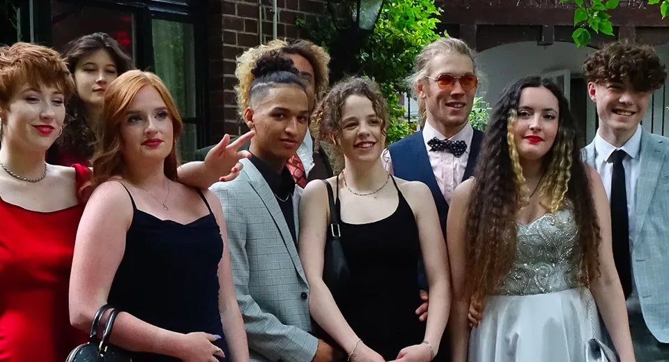 Un gruppo di studenti e studentesse del Salisbury Sixth Form College posa davanti a un edificio con aree verdi.