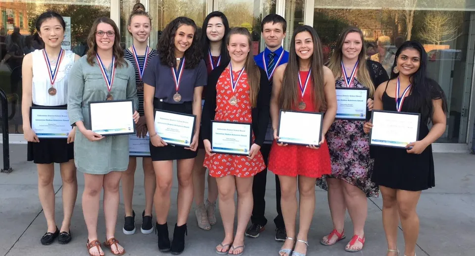 Alcune studentesse della Kingston Secondary School ricevono attestati e medaglie in un contesto solenne.