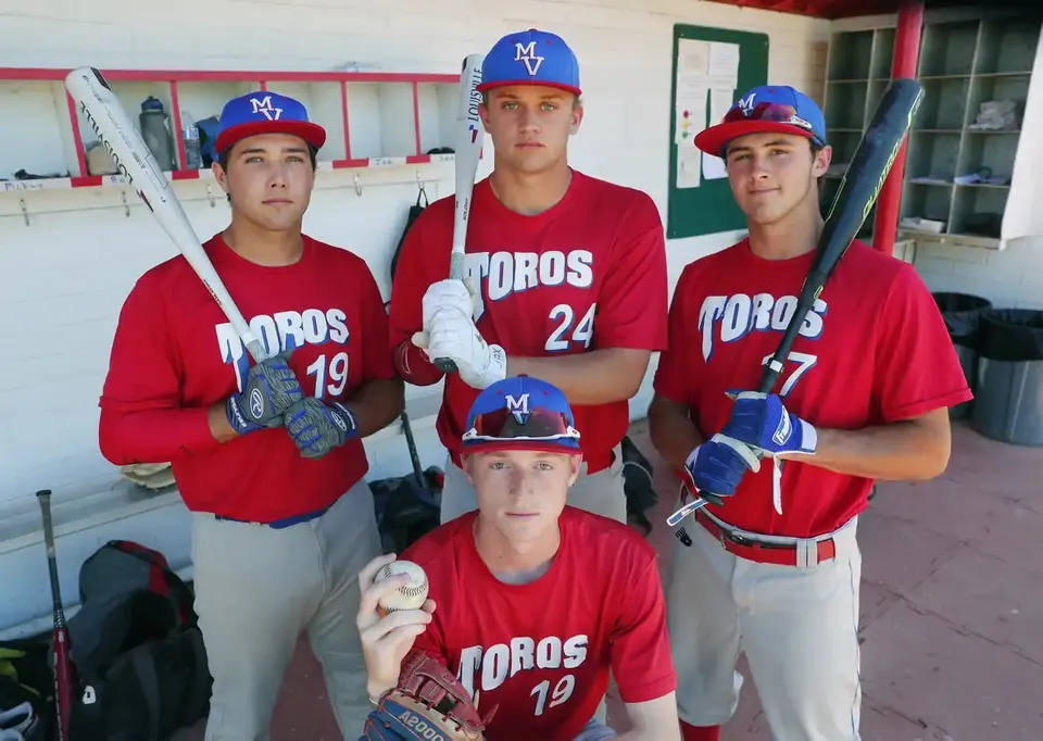 Tre studenti della Mountain View High School in divisa da baseball si trovano nel dugout.