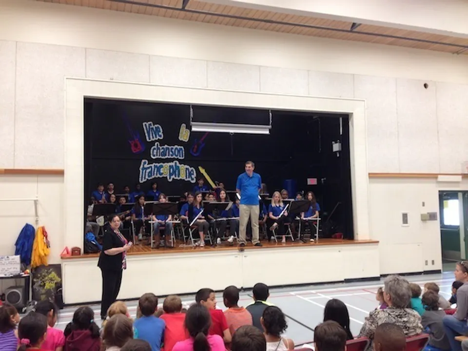 Un gruppo di musicisti e un direttore d'orchestra eseguono un concerto sul palco della École des Deux-Rives.